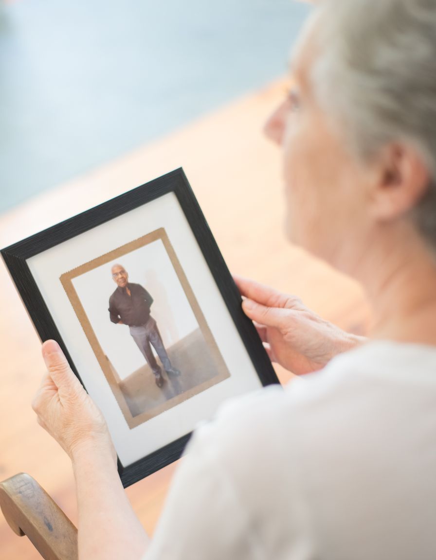 Woman holding a family portrait by the window