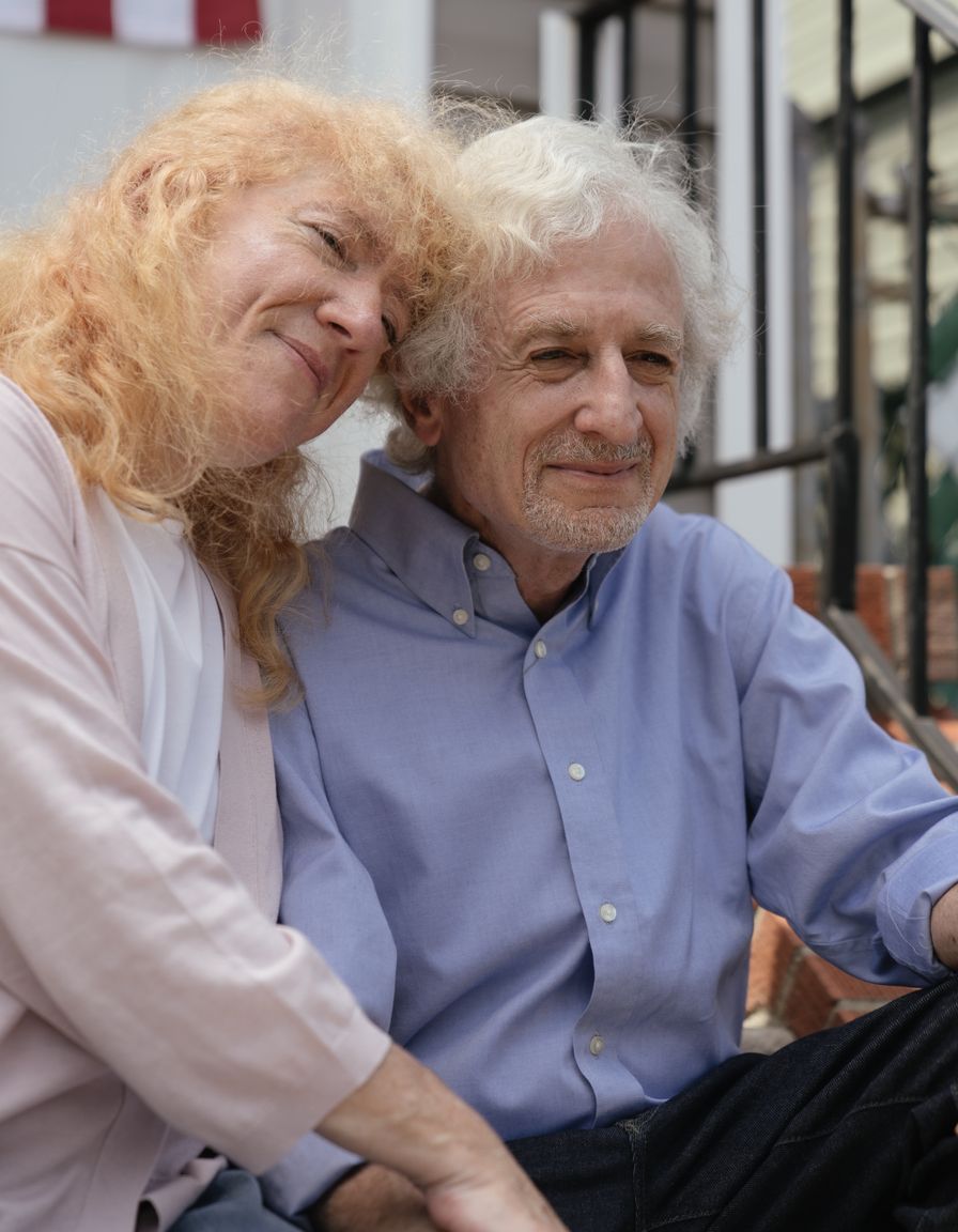 Older couple sitting together on the front steps of their home