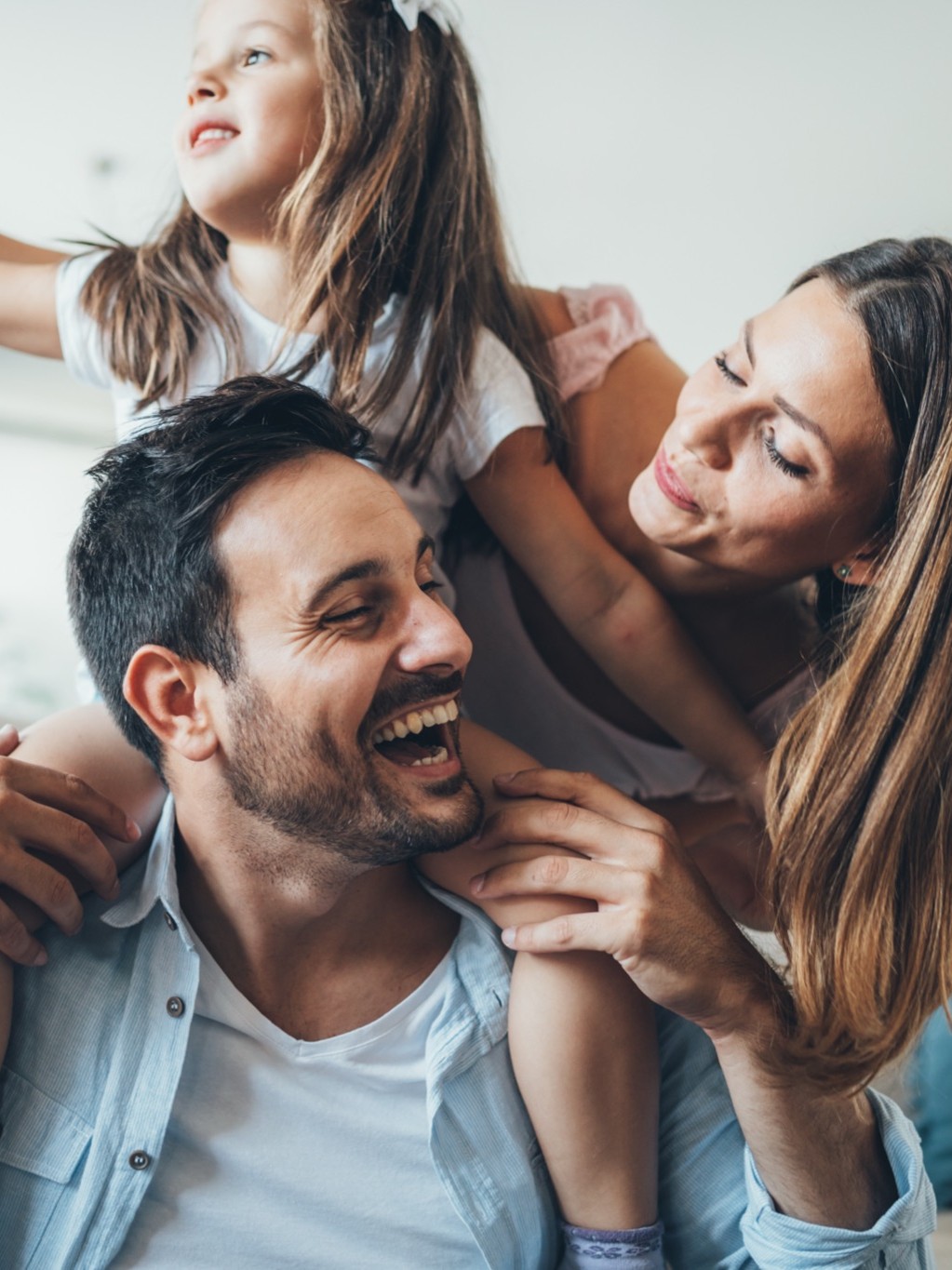 A young family laughing and playing together at home