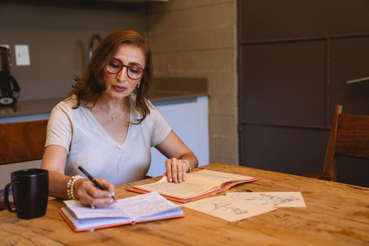 Woman writing calmly in her kitchen in the morning